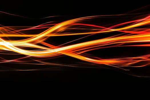 Dynamic abstract orange and yellow light streaks on black background.