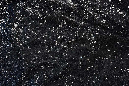 Black fabric with glittering silver sequins creating a sparkling night sky effect.