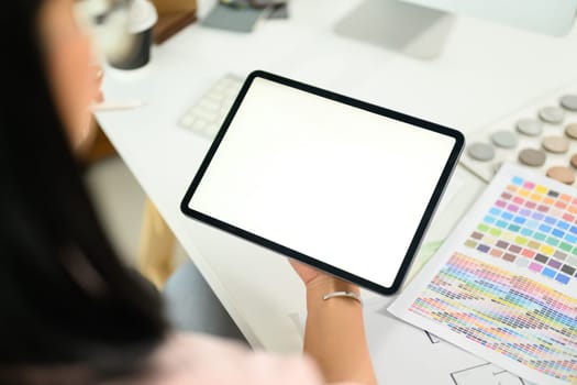 Close up of designer holding digital tablet with blank screen ready for sketching or design planning.