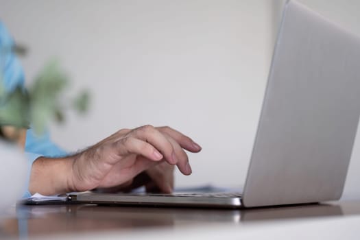 A business professional hand typing on a laptop, emphasizing productivity and the dynamics of remote work in a contemporary workspace.