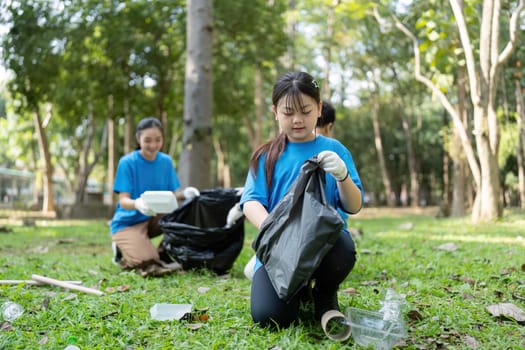 A family of volunteers diligently gathers garbage in a park, highlighting their focus on environmental responsibility and teamwork.