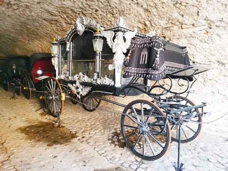 Luxurious royal carriage decorated with statues and decorative elements. Retro transport. Carriage on large wheels for important persons