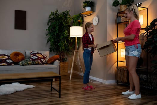 A very joyful child happily receives a special gift from a kind woman in a warm and inviting living room