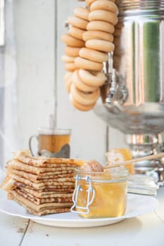 Russian pancakes with honey and a cup of tea from a vintage samovar Maslenitsa festival concept, High quality photo