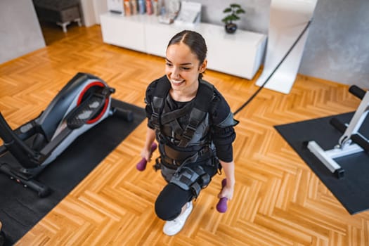 A person engages in electric muscle stimulation workout using weights.