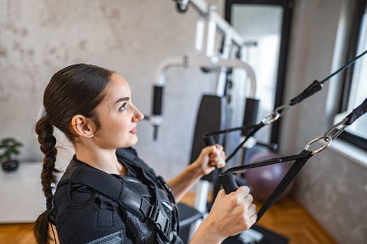 A woman uses innovative tech for an intense strength workout.