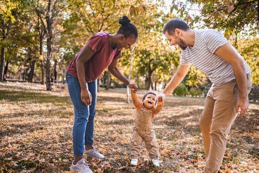 Joyful swing between parents in the park.
