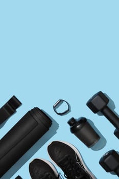 Black workout equipment for training at home on blue background. Fitness, sport items, healthy lifestyle concept. Copyspace