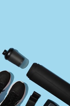 Black workout equipment for training at home on blue background. Fitness, sport items, healthy lifestyle concept. Copyspace