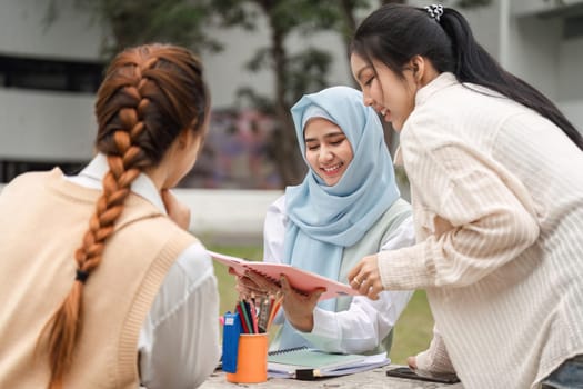 A diverse group of female students collaborating on their studies outdoors, sharing notes and discussing ideas in a university environment.