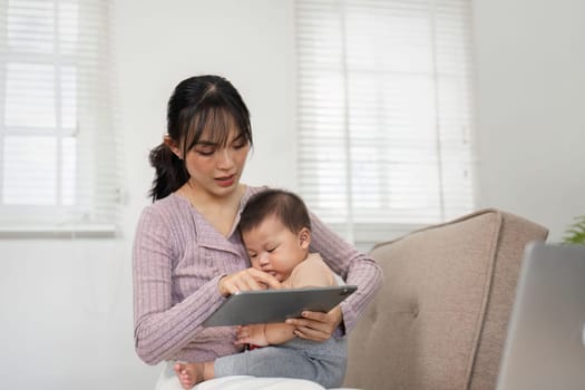 A mother and her baby enjoying interactive tablet time together in a cozy home environment, fostering learning and connection.