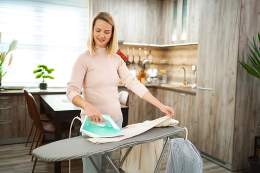 Woman smiles as she irons a garment in her stylish kitchen setting.