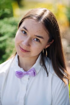 Portrait of a cheerful schoolgirl wearing a bow tie, smiling on her first day of school, ready for a new academic year