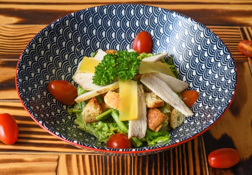 Caesar salad in blue bowl close up