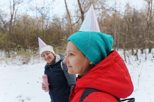 Winter celebration in the woods with friends wearing festive hats and enjoying the snowy landscape