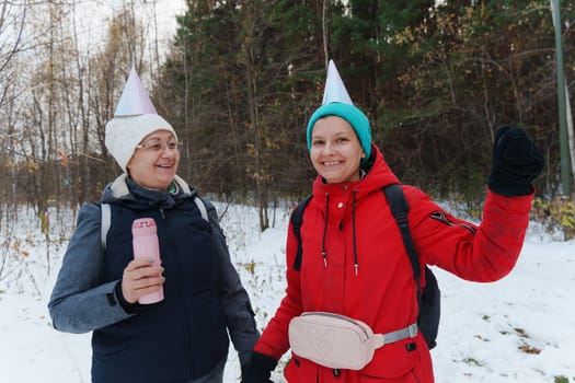 Winter celebration in the woods with friends wearing festive hats and enjoying the snowy landscape