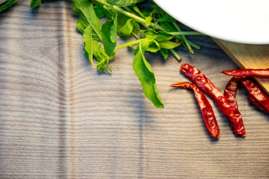 Dried chillies, basil leaves on wooden background
