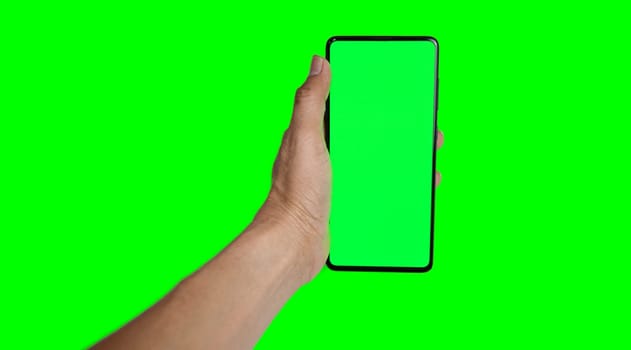 hand holding a green smartphone on a green background