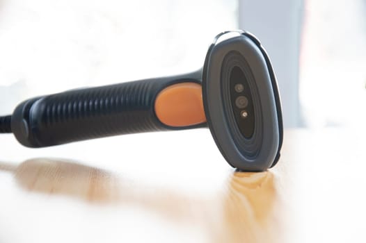 barcode scanner placed on a brown wooden floor