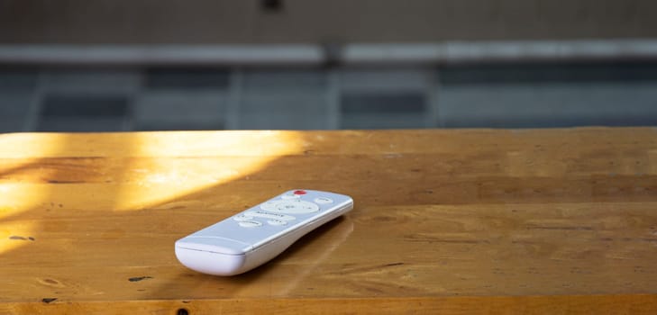 White remote control placed on wooden floor