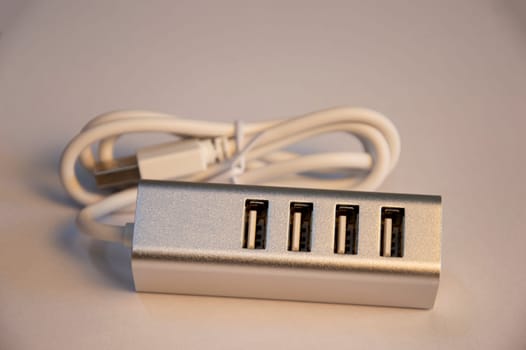 USB hub with 4 ports, silver, placed on a white background