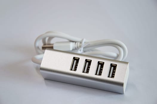 USB hub with 4 ports, silver, placed on a white background