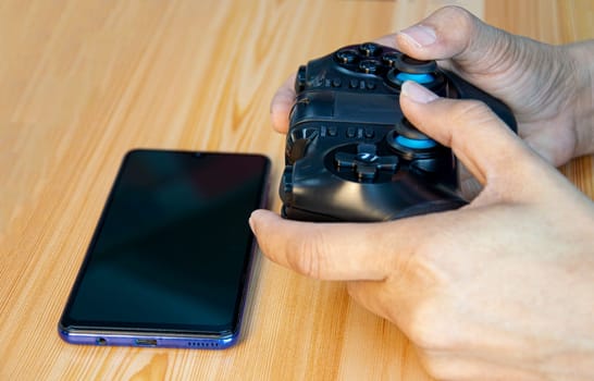 Side view of a joystick gaming device, holding a joystick.