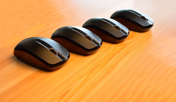 Black wireless mouse placed on wooden floor