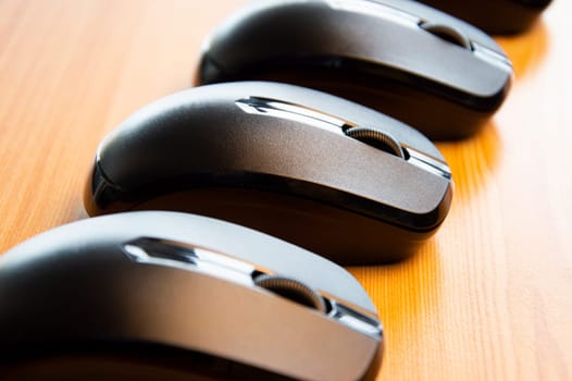 Black wireless mouse placed on wooden floor