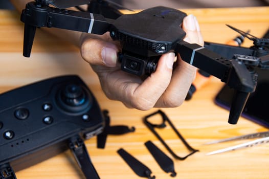 Professional mechanic repairing a drone on the table with various tools in modern workshop