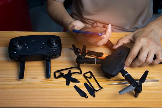 Professional mechanic repairing a drone, setting it up, on a table with various tools. in modern workshop