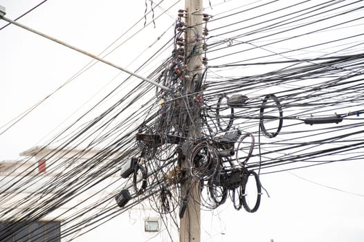 Electric wires are tangled on poles. The most common electrical cable in Thailand.