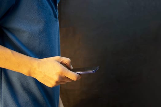 Man using smartphone against black background