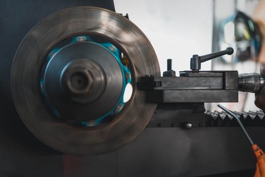 Car mechanic or serviceman disassembly and checking a disc brake and asbestos brake pads for fix and repair problem at car garage or repair shop