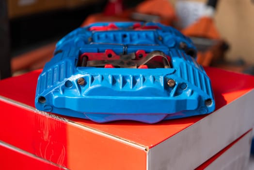 Car mechanic or serviceman disassembly and checking a disc brake and asbestos brake pads for fix and repair problem at car garage or repair shop