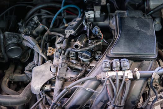 Car mechanic drain the old lubricant engine oil at car garage for changing the oil in a car engine