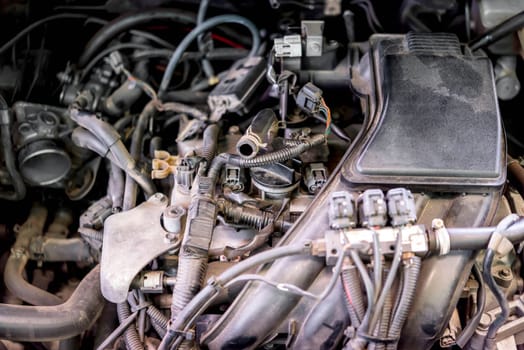 Car mechanic drain the old lubricant engine oil at car garage for changing the oil in a car engine