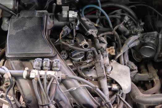 Car mechanic drain the old lubricant engine oil at car garage for changing the oil in a car engine