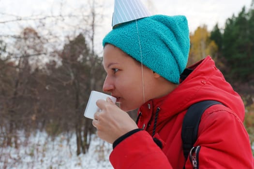 Celebrating friendship in a snowy forest with warm drinks and playful hats during a winter gathering
