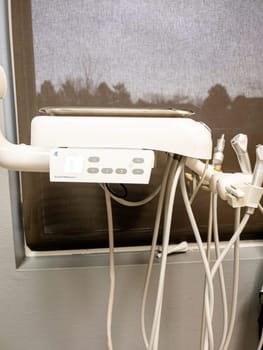 Denver, Colorado, USA-January 11, 2024-Close-up view of advanced dental office equipment, possibly an ultrasonic cleaner or other sterilization unit, set against a stainless-steel backdrop. It features a prominent digital interface and is connected by various tubes and cords, suggesting its role in patient care procedures.
