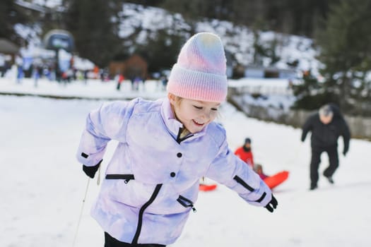 A girl with bob sledding in the snow in the mountains