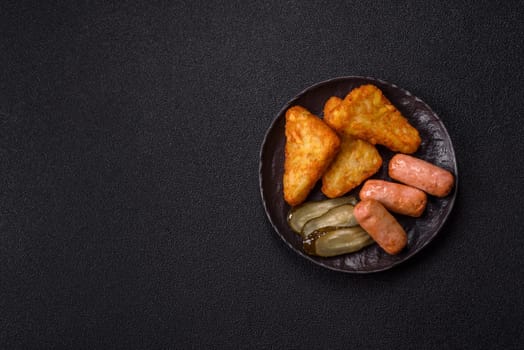 Hash browns with potatoes and onions, salt and spices on a dark concrete background