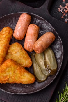 Hash browns with potatoes and onions, salt and spices on a dark concrete background