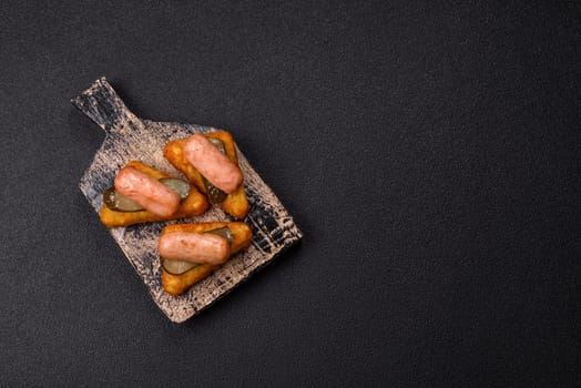 Hash browns with potatoes and onions, salt and spices on a dark concrete background