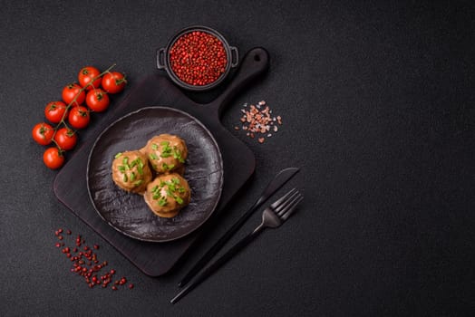Meatballs with salt and spices in creamy caramel sauce on a dark concrete background
