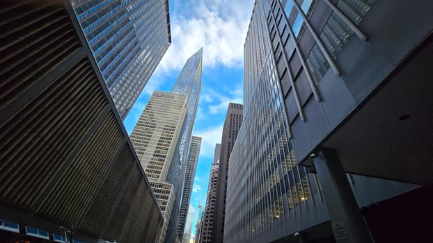 Modern look of a big metropolitan city with illuminated skyscrapers and classic architecture under a clear blue sky. Urban hustle and warm lighting create a vibrant and captivating cityscape. good for multimedia background