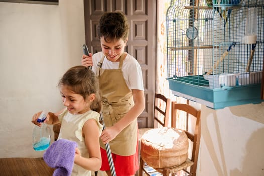 Two children enjoy tidying up their living space with cheerful expressions and teamwork, showcasing family togetherness and household chores.