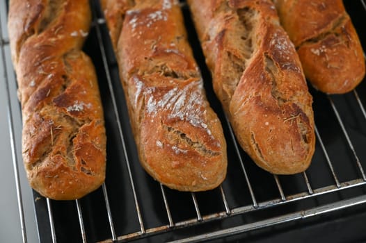Golden-brown loaves rest on a cooling rack, showcasing their rustic charm and inviting aroma in a cozy kitchen.