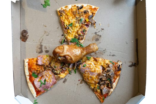 A pizza box displays slices topped with ham, mushrooms, and cheese, while a chicken drumstick rests in the center. Grease marks show it has been enjoyed recently.