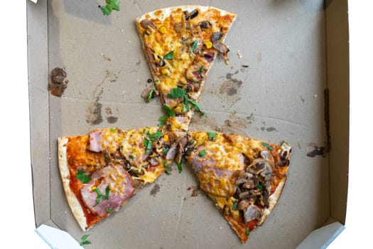 Leftover slices of pizza topped with ham, mushrooms, and herbs sit in a takeout box after a casual meal. The empty sections reveal the once full pie enjoyed by friends or family.
